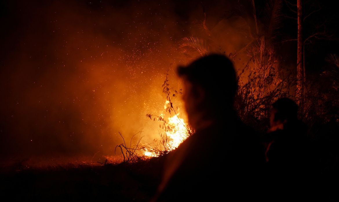 Fire rises near members of the armed forces as Bolivia records the most outbreaks of wildfires since 2010 this year, burning some 3 million hectares (7.5 million acres) of land according to experts, in Nuflo de Chavez province, Bolivia August 25, 2024. REUTERS/Claudia Morales