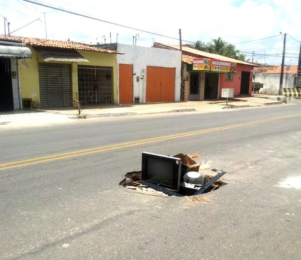 Aparehos de TV sinalizam o buraco, que fica no meio da Rua José Luiz Silva, no bairro de Nossa Senhora da Apresentação, Zona Norte de Natal — Foto: Pheterson Alan